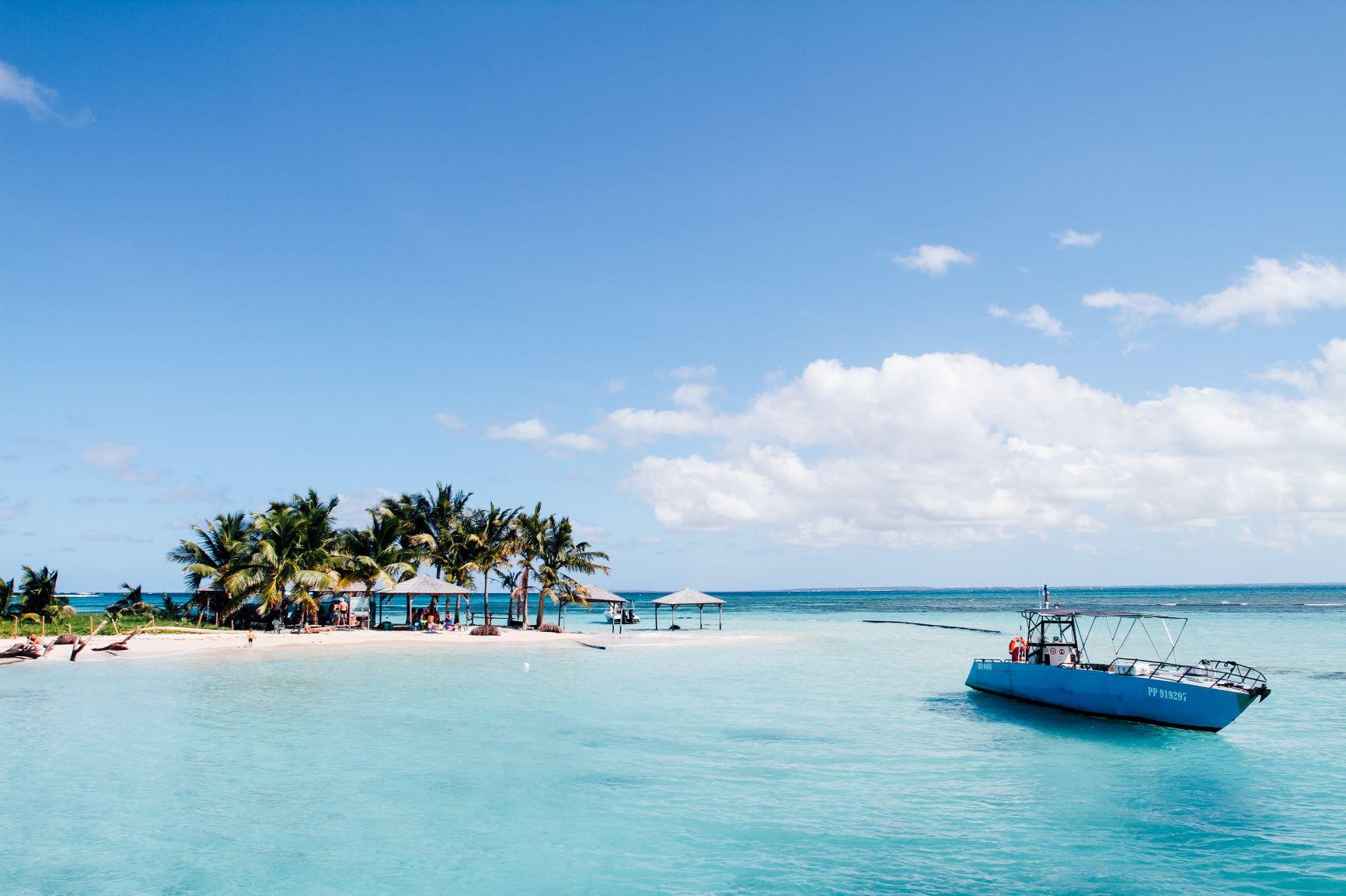 Yacht in paradiesisch klarem, blauem Wasser vor der Küste mit Palmen von Guadeloupe  