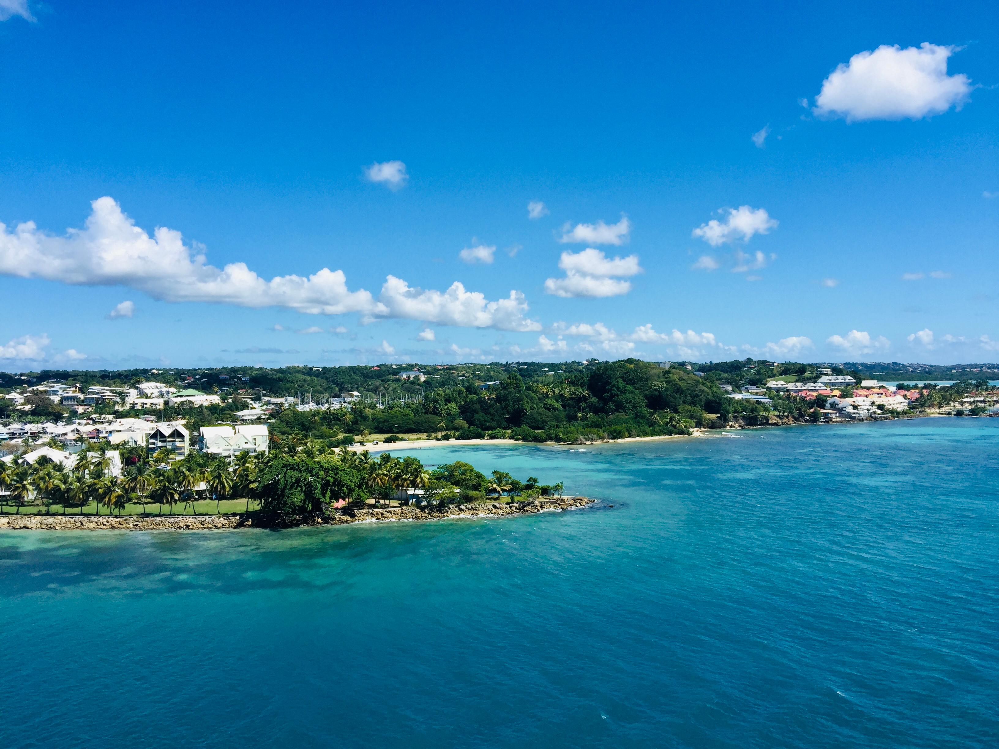 Landzungen an der Küste der Karibik mit Palmen, weißen Hausern in himmlisch blauem Meer