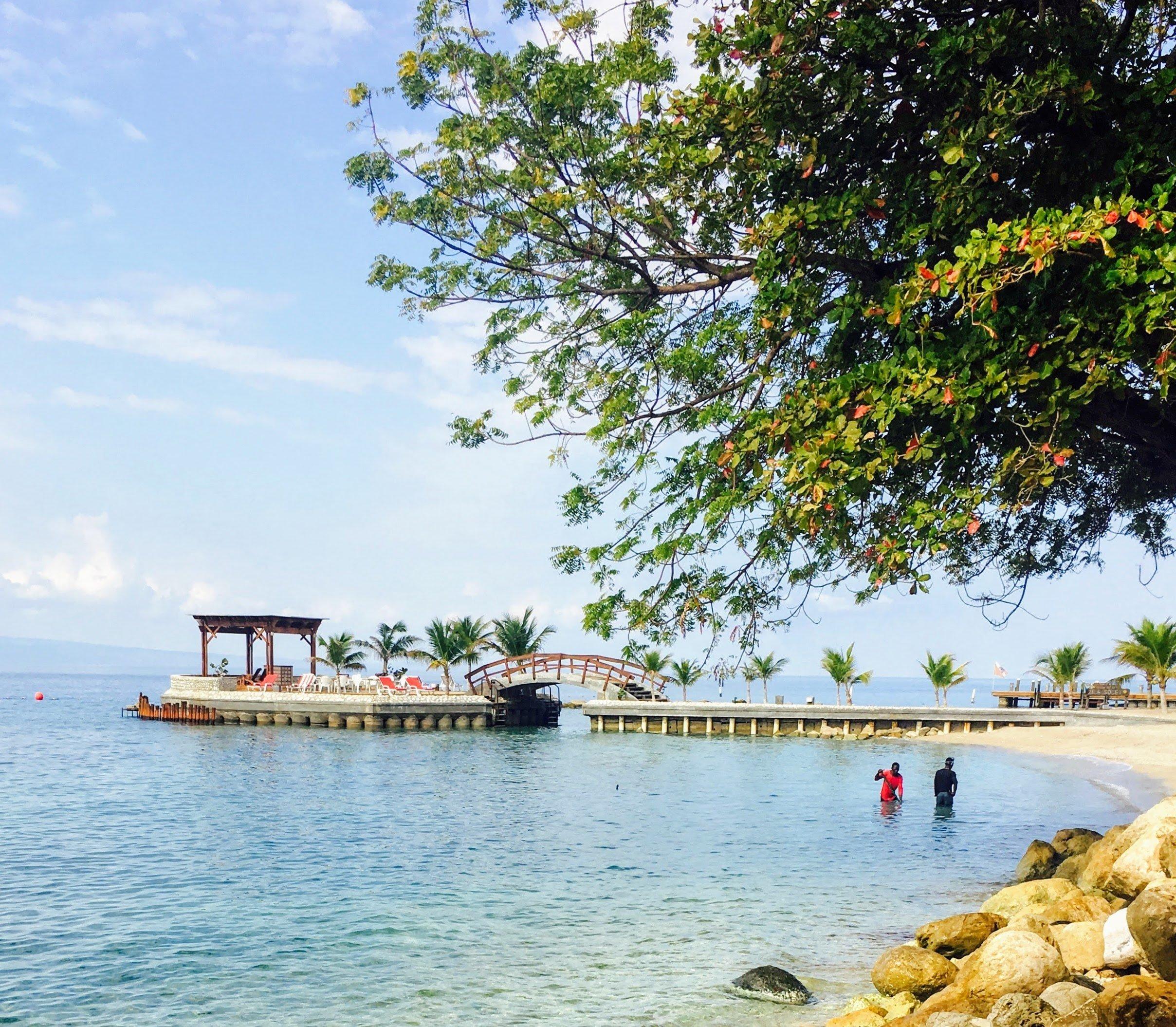 begehbarer Steg für Touristen an der Küste Tortolas in klarem Meer mit Einheimischen im Vordergrund