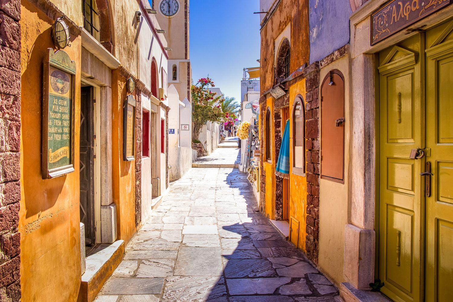 Sonnenbeschienene Gasse in Griechenland mit bunten Häusern